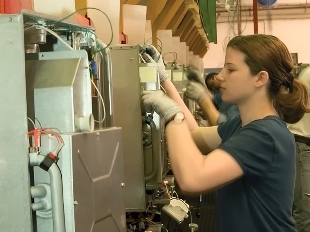 Immagine storica di un'operatrice al lavoro sulla linea produttiva dell'azienda Ferroli negli anni 2000